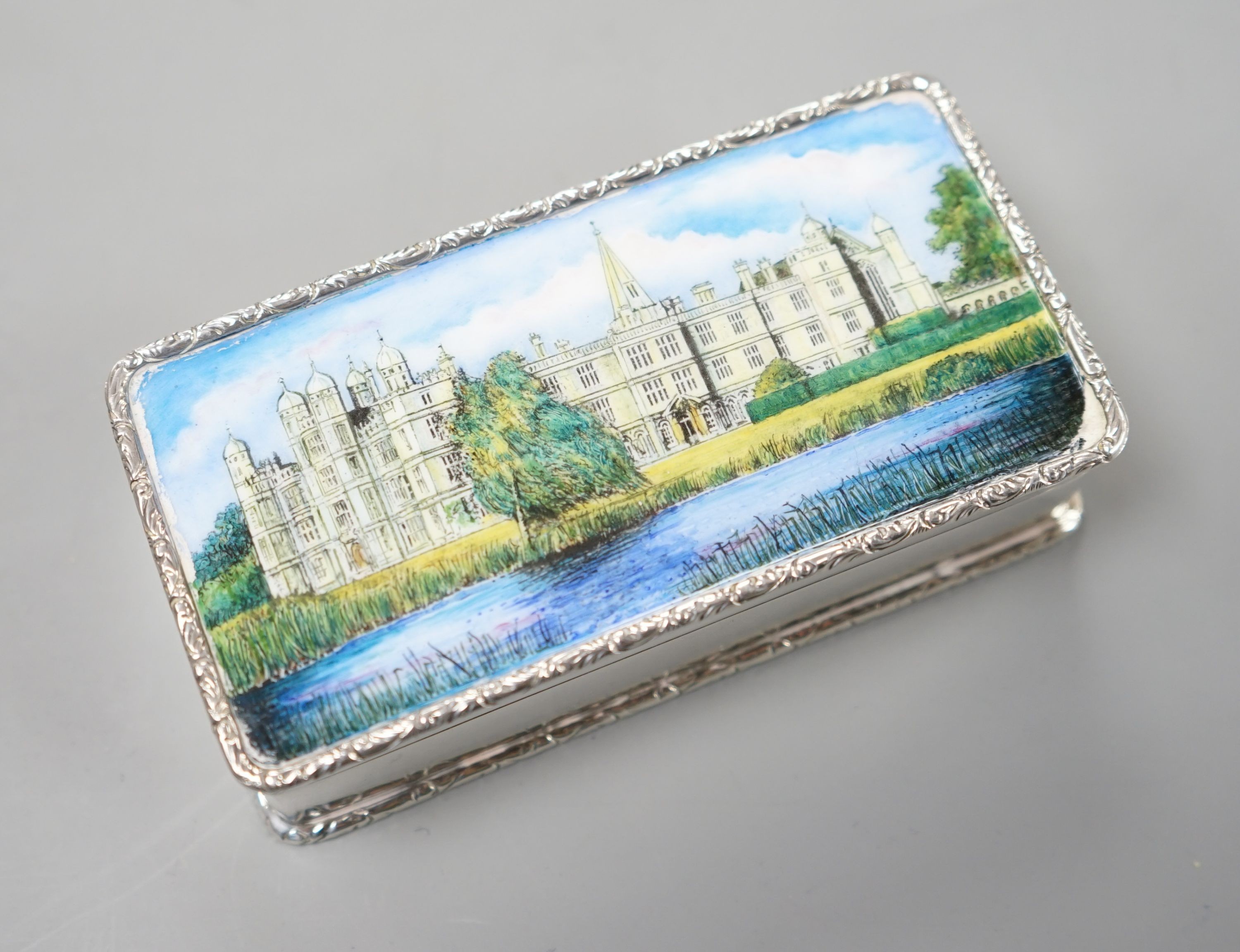 A modern Garrard & Co silver and enamel snuff box, decorated with manor house scene, Birmingham, 1986, 94mm, gross 147 grams.